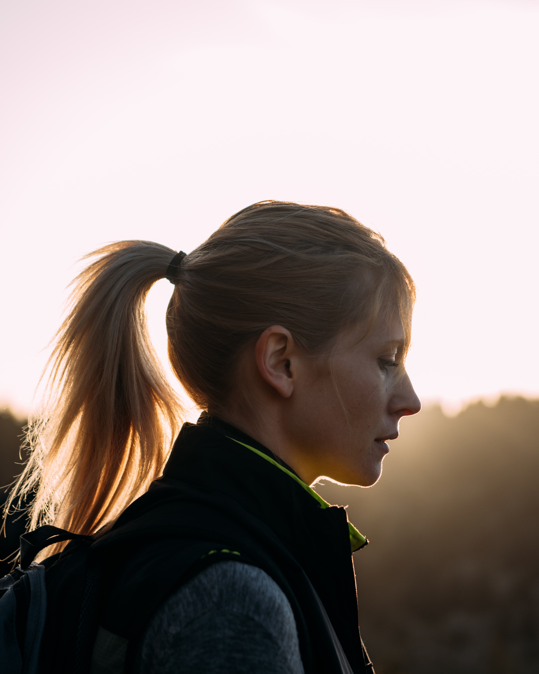 Randonneuse de profil dans la montagne au coucher du soleil