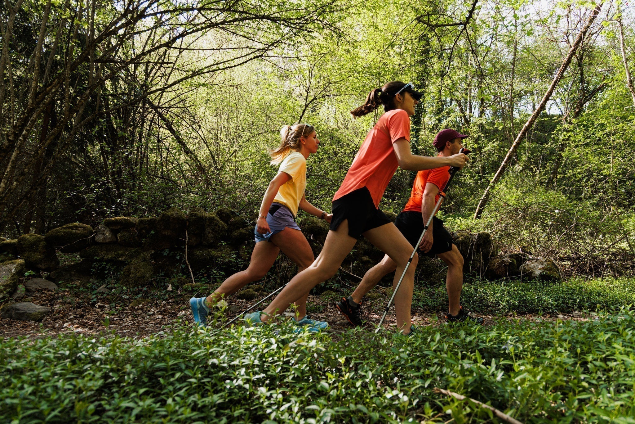 3 personnes en forêt en train de pratiquer la marche nordique