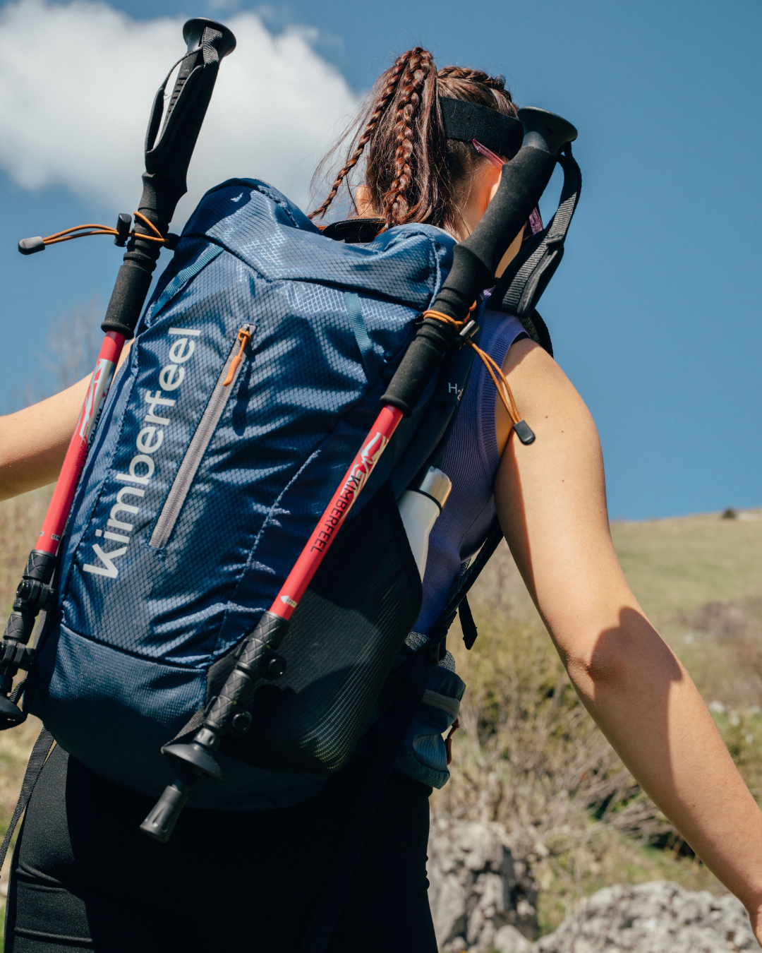 Randonneuse de dos portant un sac à dos avec accroches pour les bâtons